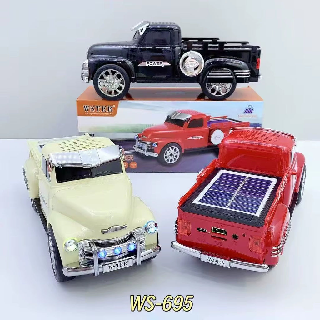 Off-road truck Bluetooth speaker with solar charging, LED headlights and moving wheels, WSTER WS-695 desk accessory.